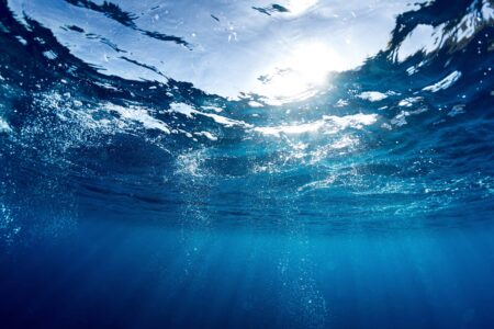 Clean water - underwater view you look through the water surface into the sky