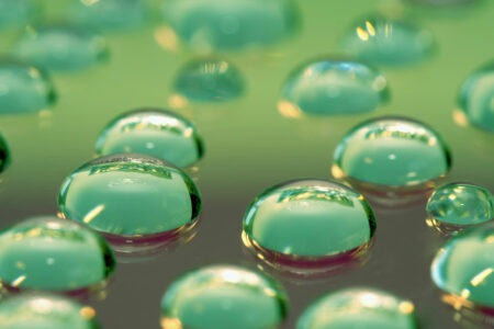 Glycerine drops on a green glass plate