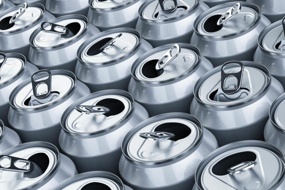 Several already opened aluminum beverage cans standing next to each other