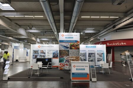 SIEBTECHNIK TEMA exhibition booth at SOLIDS Dortmund 2026, showing the Multiple-Deck-Sizer (MDS) and experts in conversation with visitors.